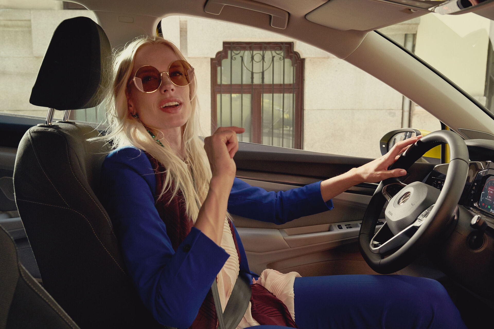 Mulher ao volante do compacto VW Golf a utilizar o comando de voz