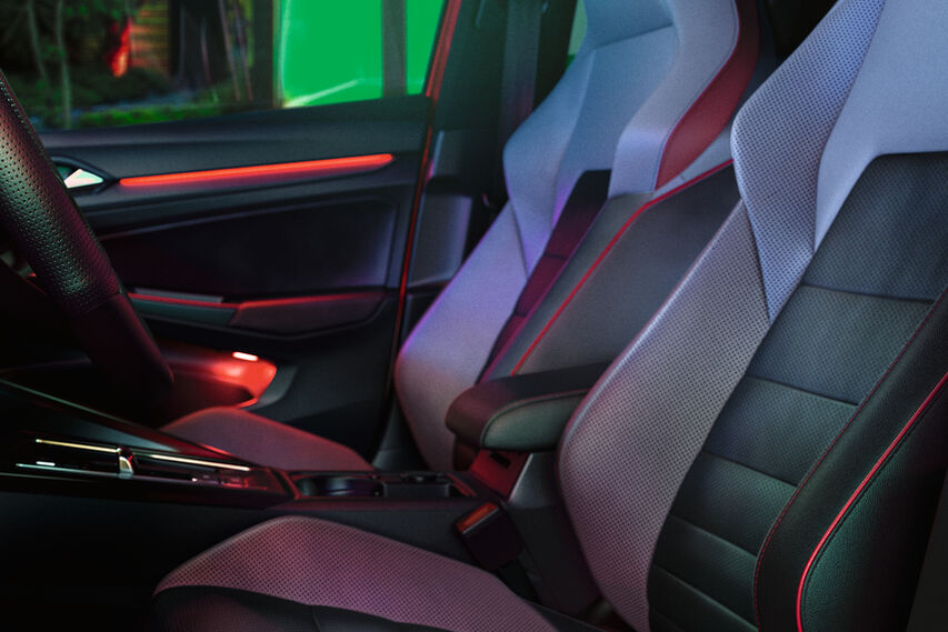 Interior do VW Golf GTI, vista detalhada dos bancos dianteiros, iluminação ambiente em vermelho