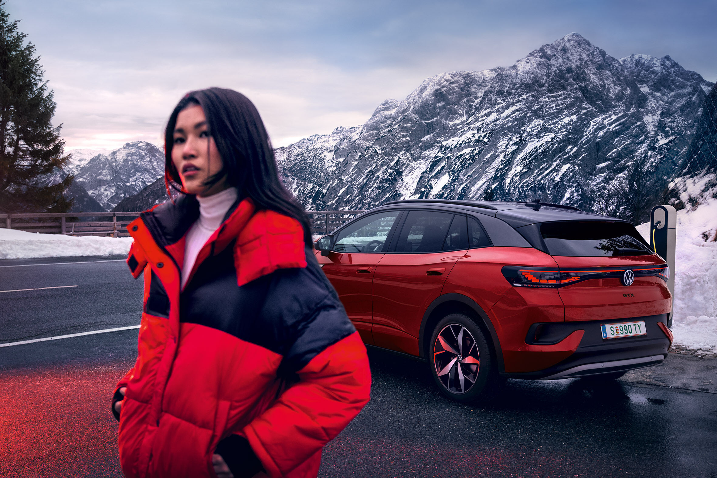 Jovem mulher de kispo vermelho em frente ao SUV desportivo 100% elétrico VW ID.4 GTX