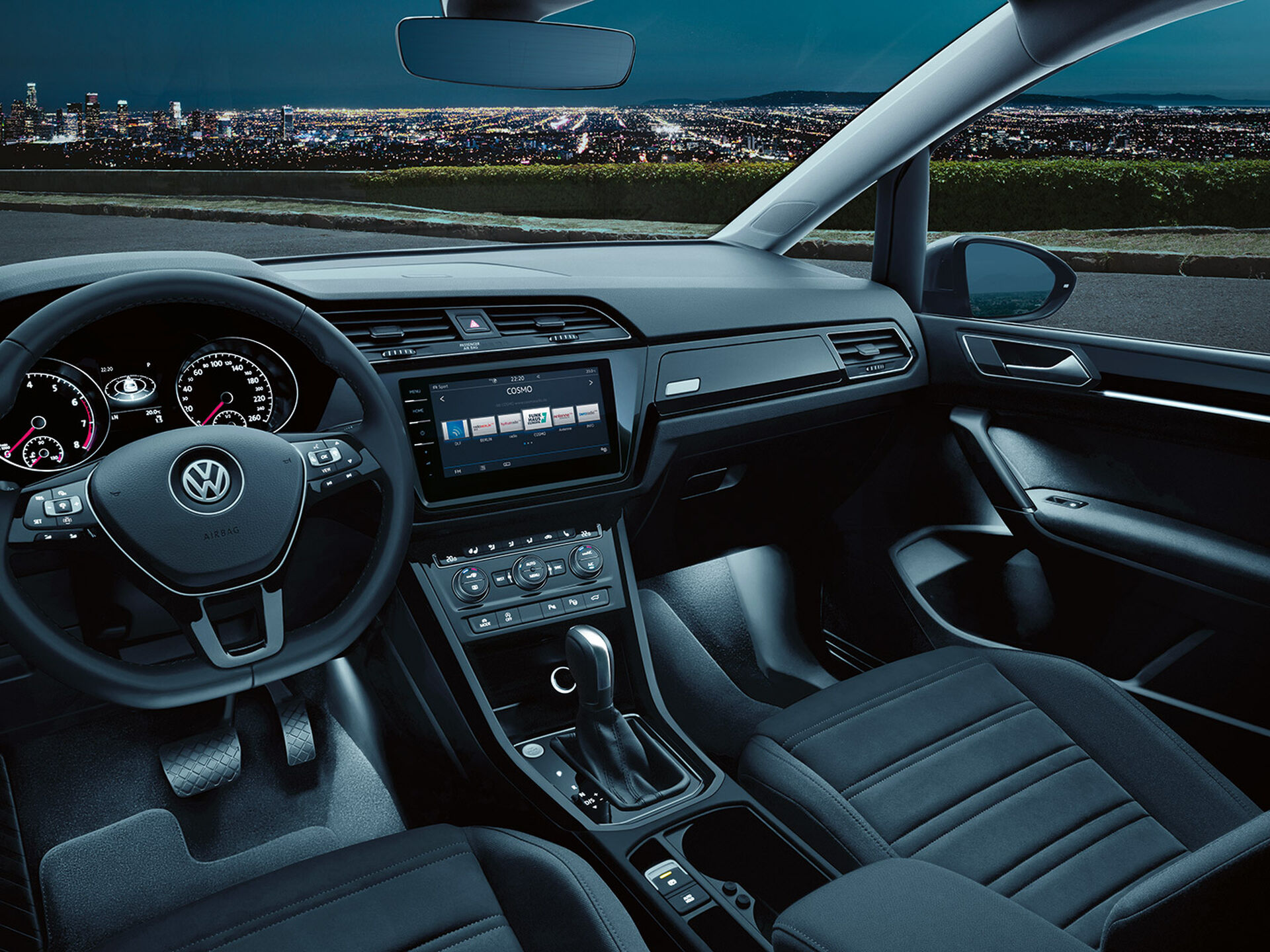 Habitáculo de um VW Touran num ambiente escuro com luz ambiente ligada