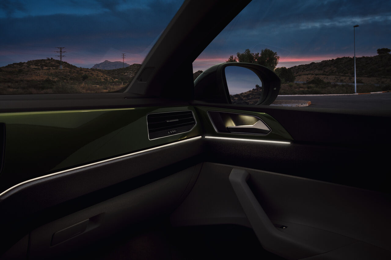Interior do VW Taigo: Vista sobre o Dashboard com iluminação ambiente ligada