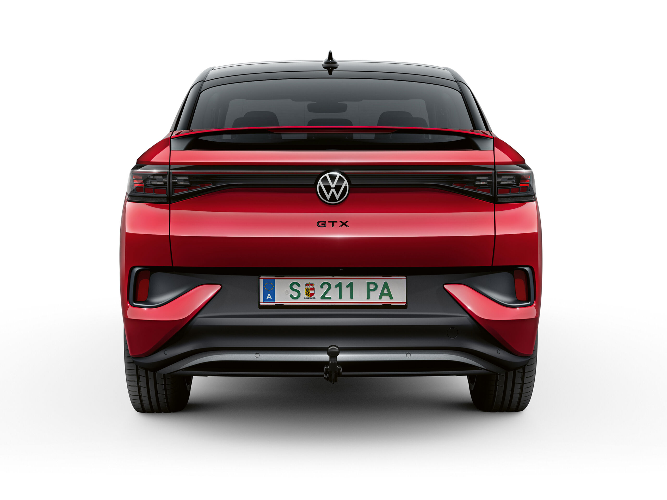 Um VW ID.5 GTX vermelho desloca-se dinamicamente numa estrada, puxando um atrelado com uma mota de cross