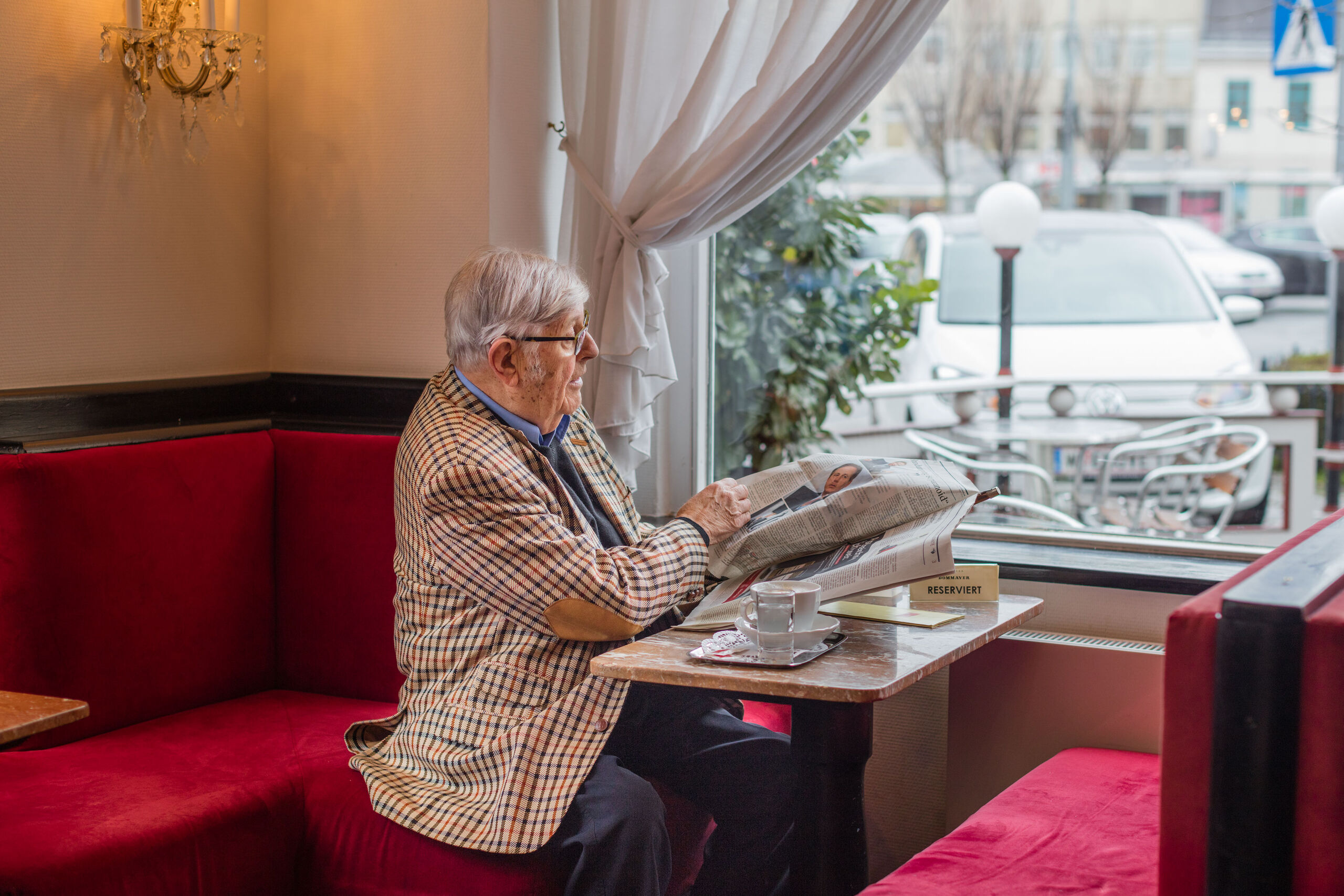 Heinz Gerhard senta-se à janela no Café Dommayer e olha para o seu e-up!