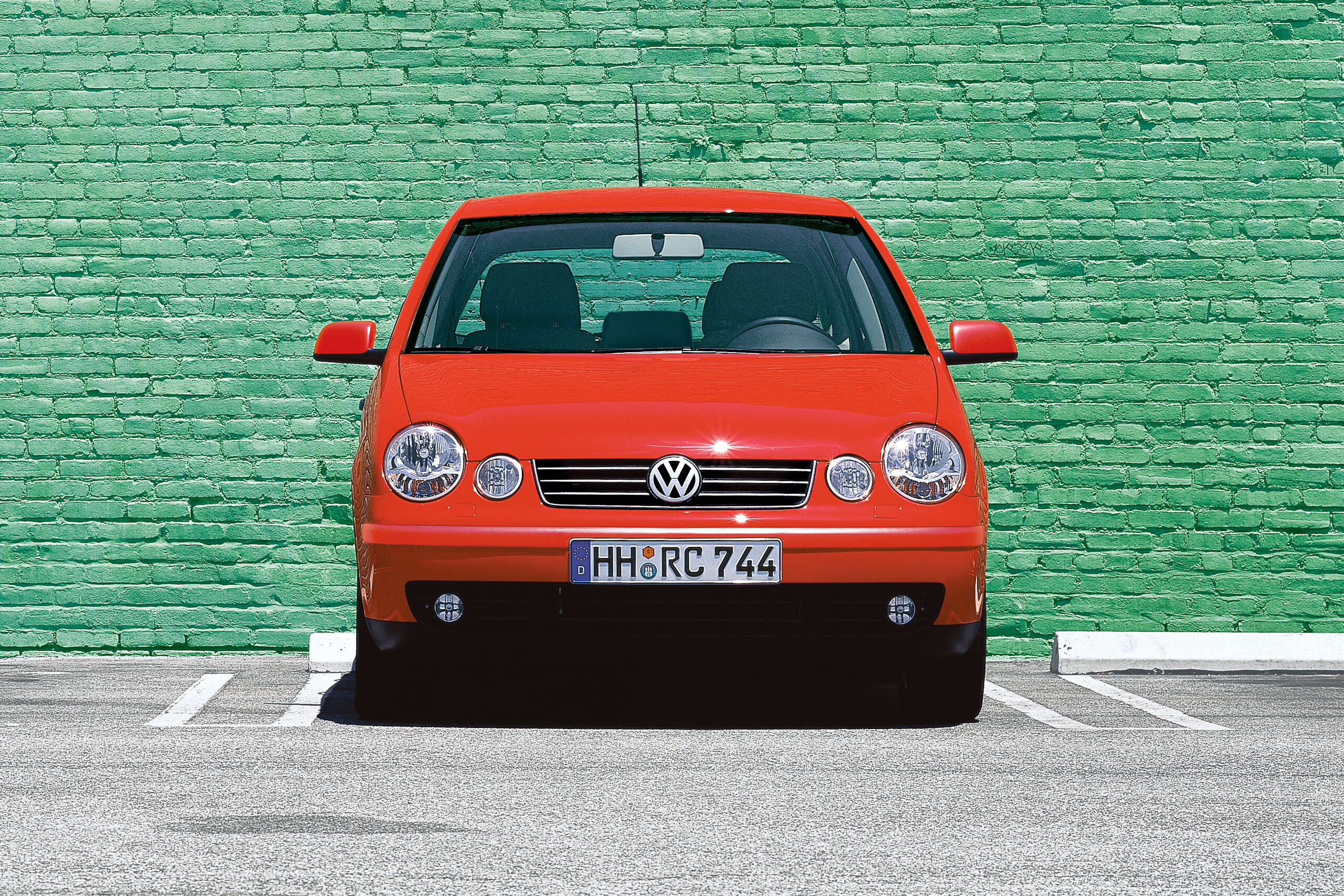 Um VW Polo vermelho 4 9N1 em frente a uma parede verde