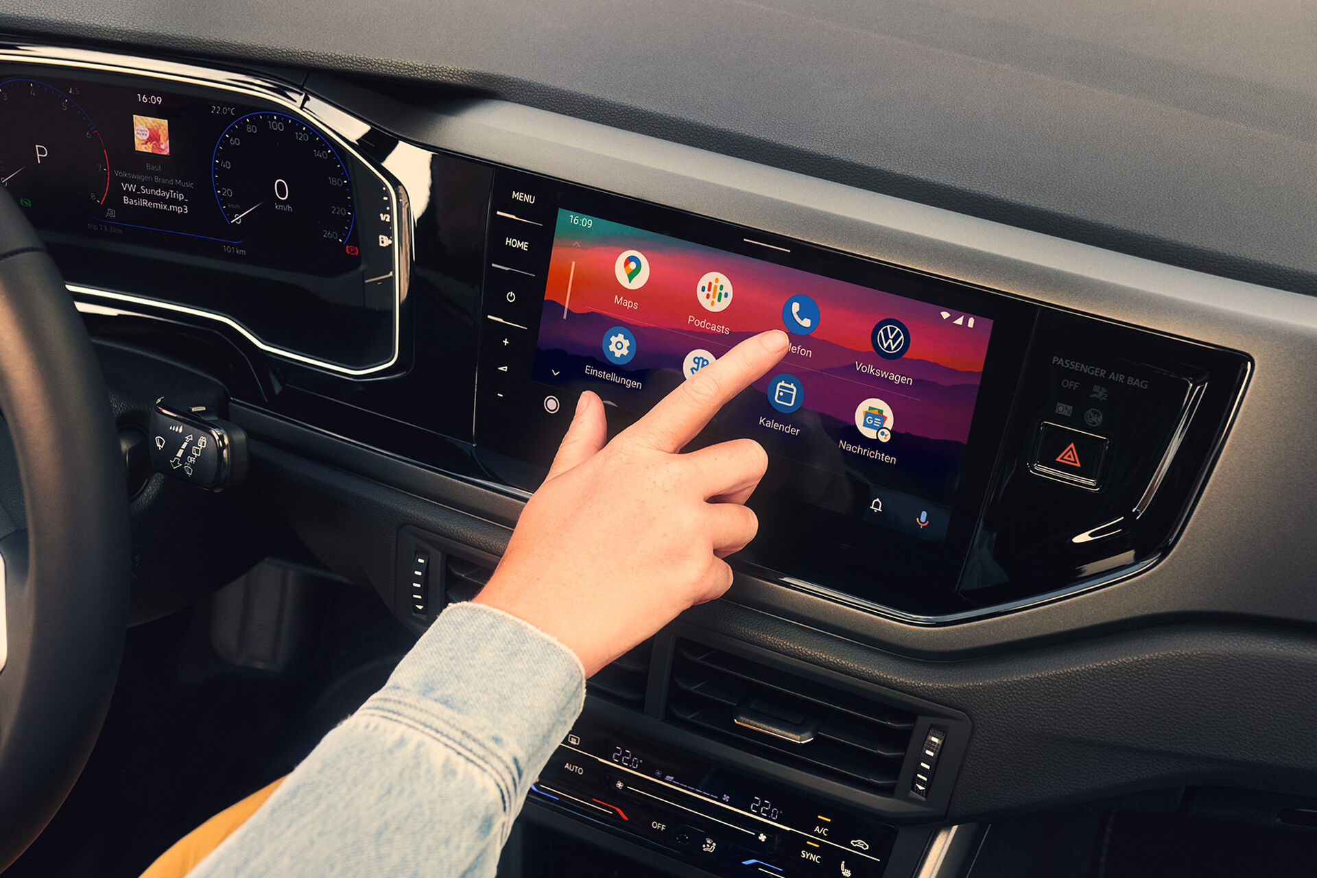 Ecrã do novo VW Polo aberto no Android Auto™ da Google. Uma mão opera o ecrã. 