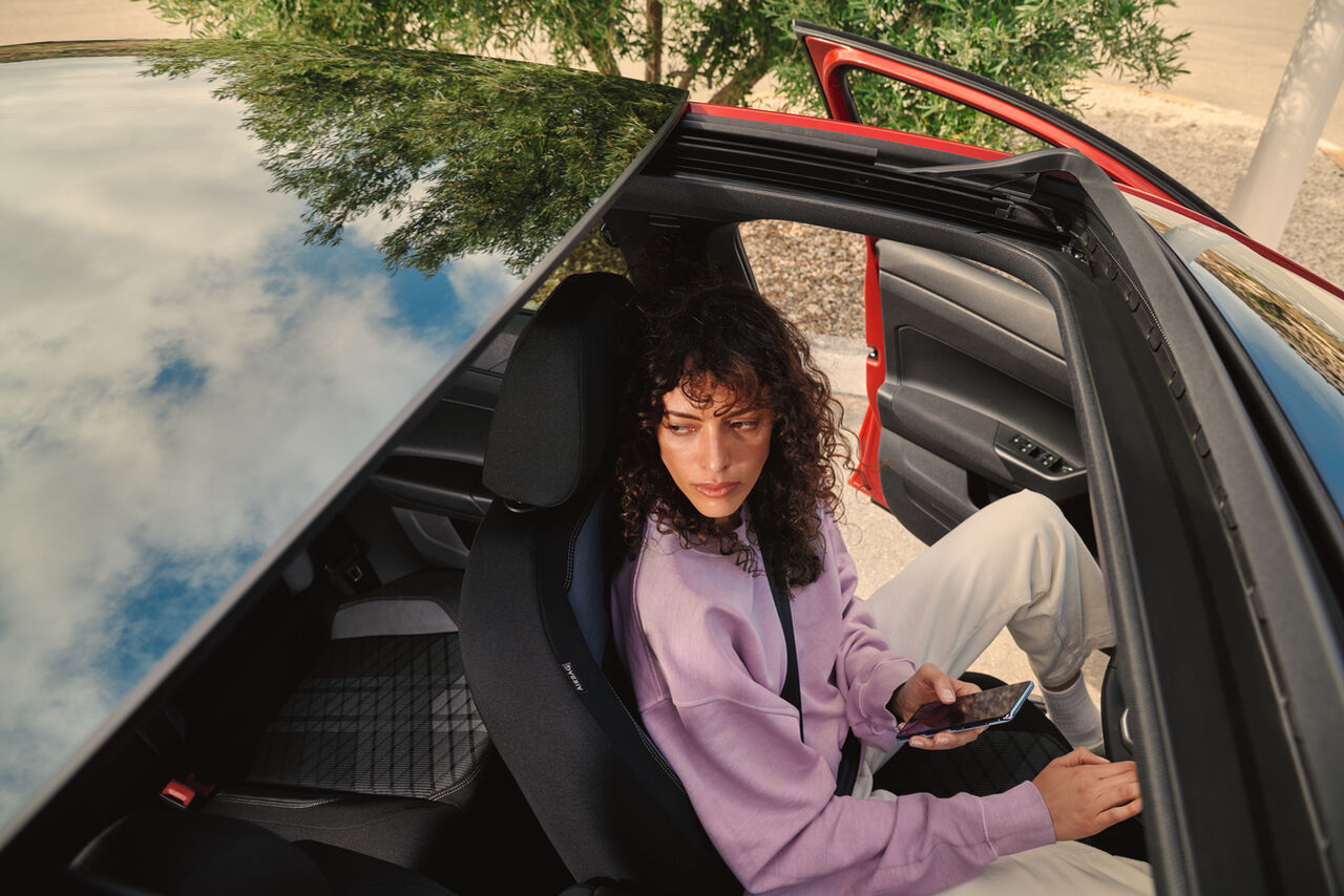 VW Taigo: Vista da mulher no banco do condutor através da abertura panorâmica/tejadilho deslizante opcional