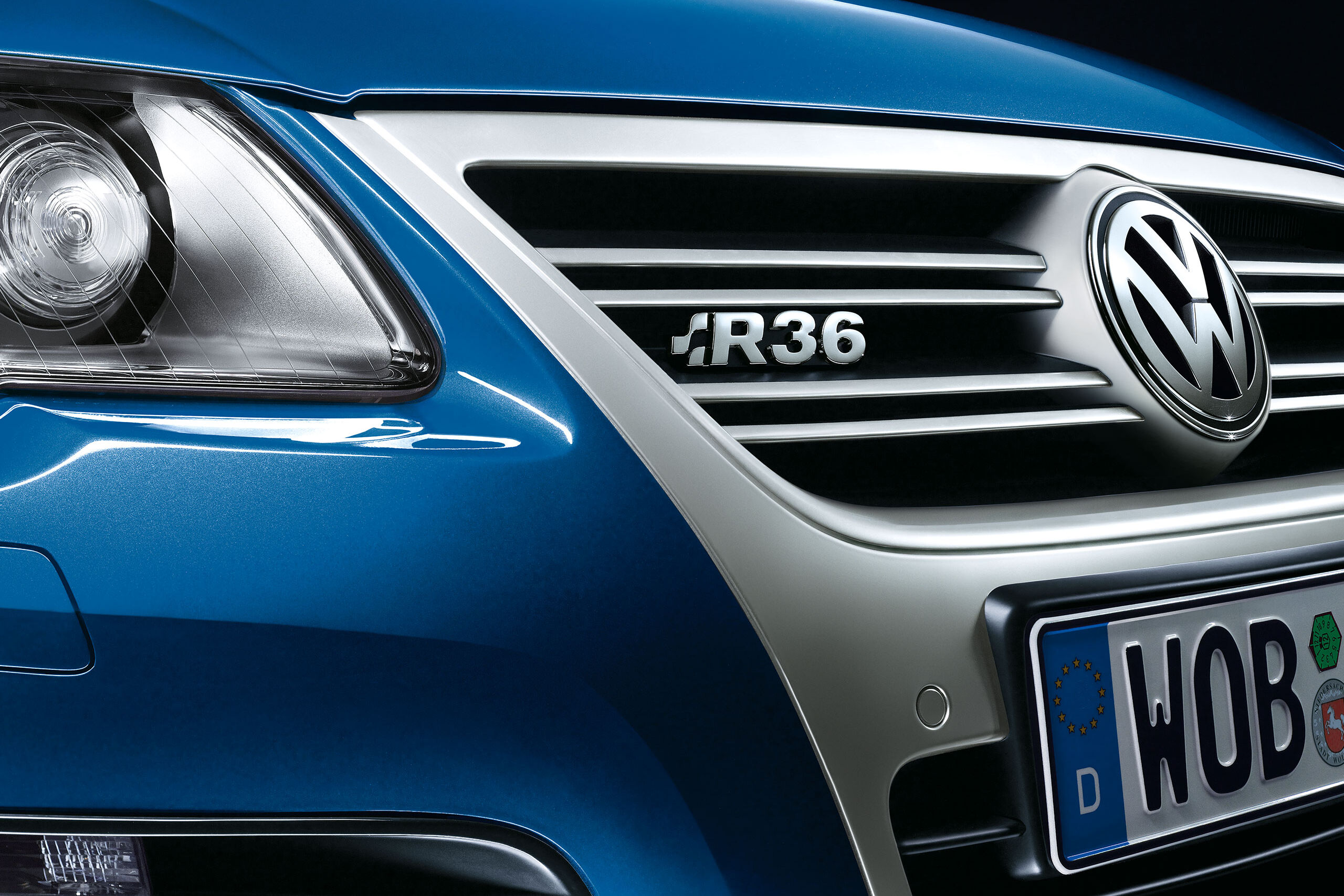 Vista detalhada de um carro VW Passat R36 azul com o emblema "R36" na grelha do radiador.