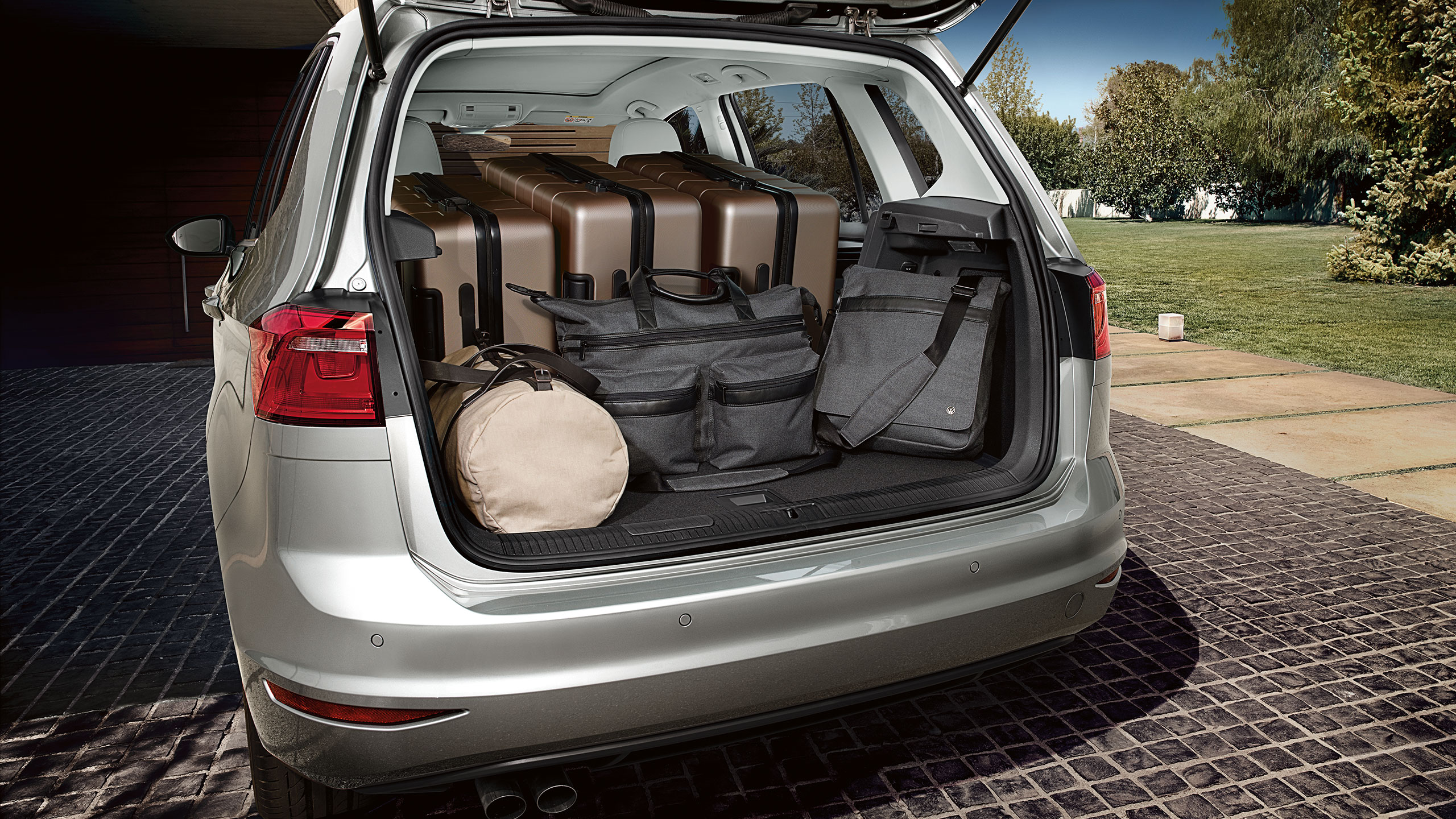 Um carro VW prateado com a bagageira aberta e arrumada com segurança.