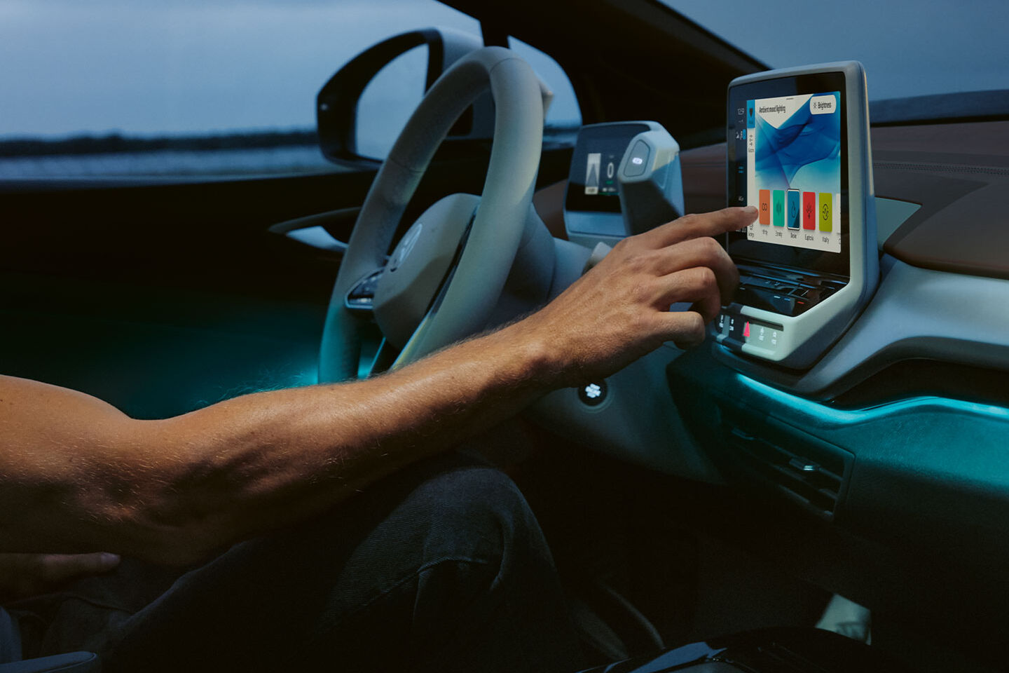 Eine Hand tippt etwas auf einem Bildschirm in einem VW ID. Modell