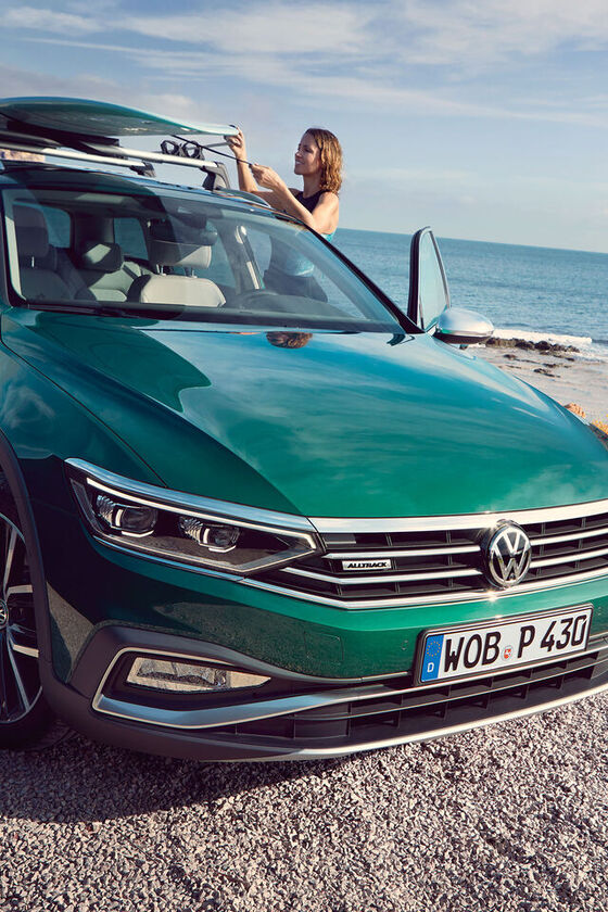 Duas mulheres vão surfar e levam as pranchas no seu automóvel VW verde