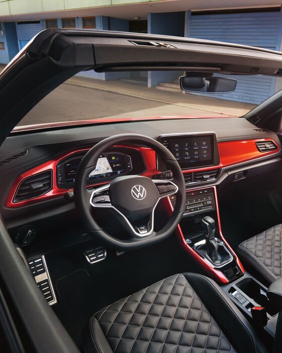 Detalhe das costuras decorativas no cockpit do VW T-Roc Cabrio, com elementos decorativos em vermelho.