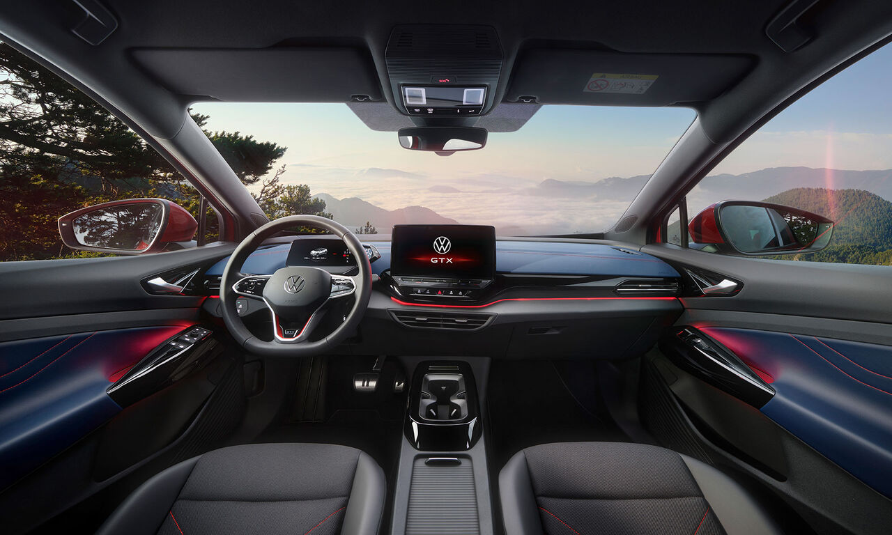 Habitáculo de um VW ID.5 GTX vermelho. Vista do volante, ecrã, bancos, molduras e espelho retrovisor.
