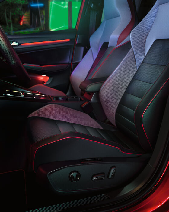 Interior do VW Golf GTI, vista detalhada dos bancos dianteiros, iluminação ambiente em vermelho