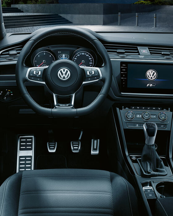 Interior de um VW Touran com equipamento R-Line e logótipo R-Line no sistema Infotainment "Discover Pro"