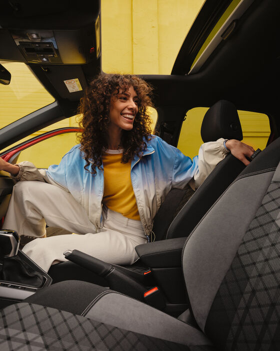 Interior do VW Taigo R-Line: Mulher sentada ao volante, olhando para trás