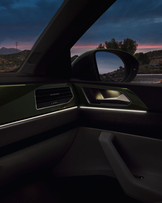 Interior do VW Taigo: Vista sobre o Dashboard com iluminação ambiente ligada