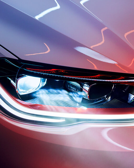 Pormenor dos faróis LED Matrix na dianteira de um VW Polo GTI branco, faixa decorativa vermelha e emblema GTI.