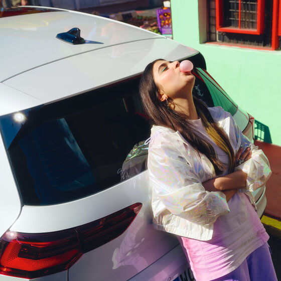 Uma rapariga está encostada à traseira do novo híbrido VW Golf GTE