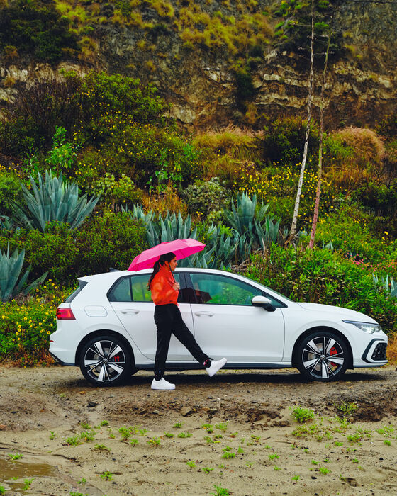 Uma mulher passa ao lado do novo carro híbrido VW Golf GTE.