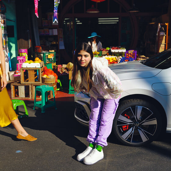 Uma rapariga faz pose em frente ao VW Golf GTE.