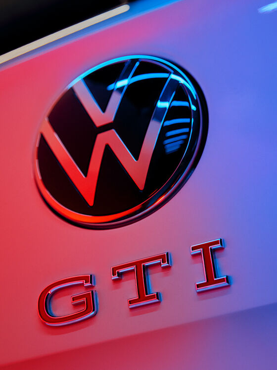 Pormenor do logótipo VW e do emblema GTI com letras vermelhas na traseira do Polo GTI.