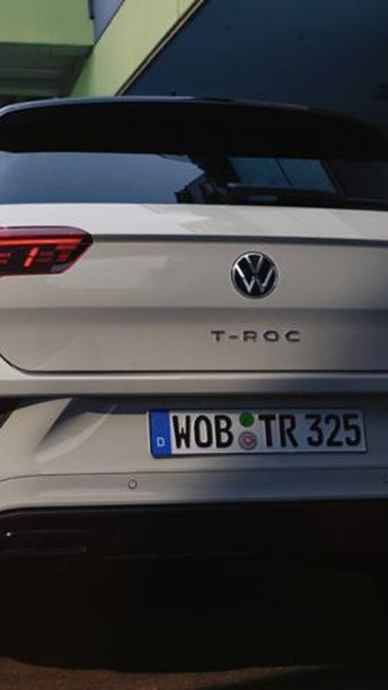Vista de trás de um VW T-Roc branco, estacionado à beira da estrada