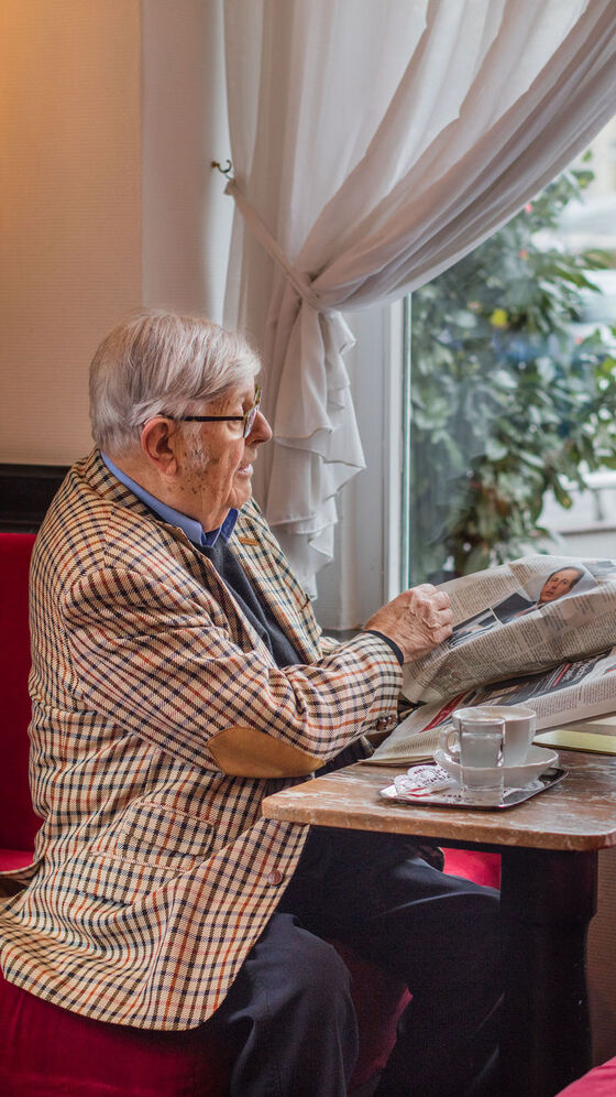 Heinz Gerhard senta-se à janela no Café Dommayer e olha para o seu e-up!