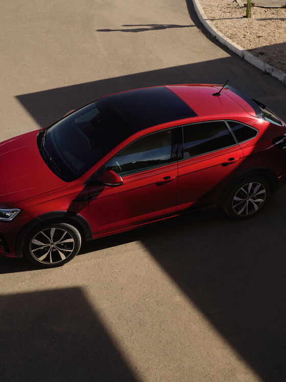 VW Taigo R-Line vermelho, visto lateralmente de cima, imagem das barras de tejadilho pretas.