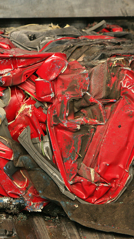 Um carro vermelho comprimido preparado para o triturador